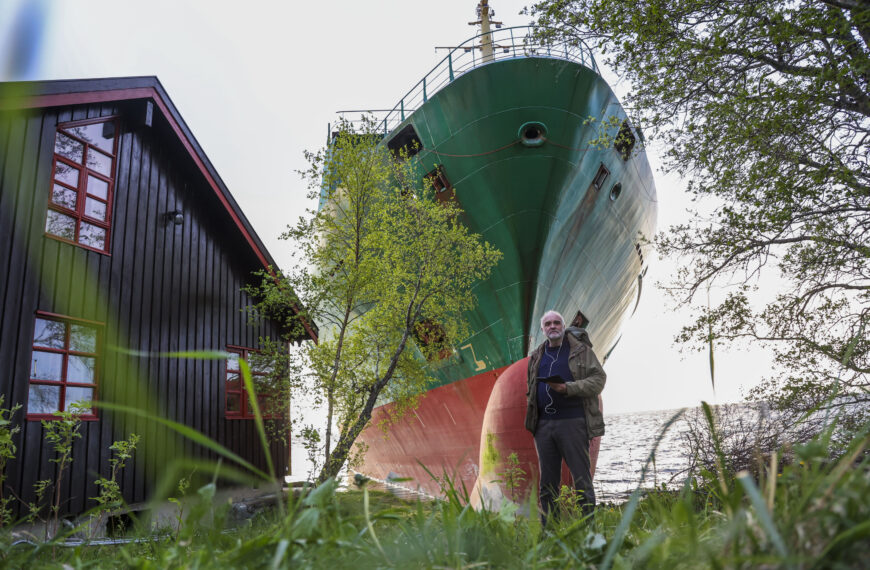 Man Wakes Up and Sees 440-Foot Ship in His Garden. LOL! (Photo: Johan Helberg stands next to his house, with the container ship NCL Salten in the background, after the 135-meter-long ship ran aground in the Trondheimsfjord, outside Byneset, in Trondheim, Norway, Thursday May 22, 2025. (Jan Langhaug/NTB Scanpix via AP)