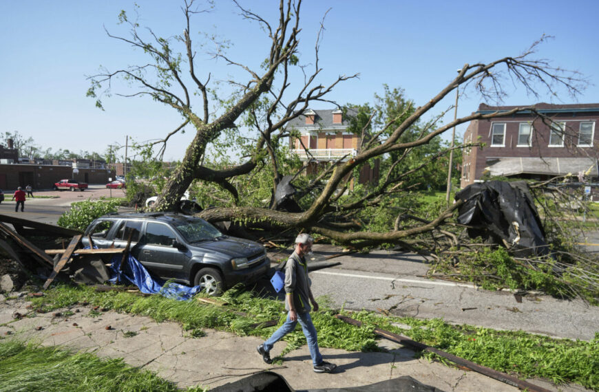 Dangerous Tornado Weekend Ahead: 90 Million Under Threat Alert (Photo: A person walks past a large tree blocking a road after a severe storm moved through Friday, May 16, 2025, in St. Louis. (AP Photo/Jeff Roberson)