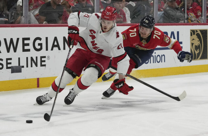Carolina Hurricanes defenseman Alexander Nikishin (21) and Florida Panthers center Jesper Boqvist (70) go after the puck during the second period in Game 4 of the NHL hockey Stanley Cup Eastern Conference finals, Monday, May 26, 2025, in Sunrise, Fla. (AP Photo/Lynne Sladky)